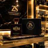 Zavya Scent's perfume bottle and packaging on a reflective surface with 'ZS' branding.